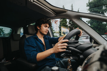 Naklejka premium A young man confidently drives a car in an urban area, focusing intently on the road ahead. The scene conveys independence and maturity.