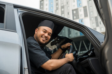 Asian muslim business man getting new car. Happy and excited. Smiling man islamic driving vehicle...