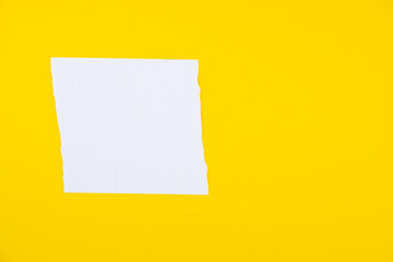 Torn white paper with rough edges on bright yellow background for creative design and advertising...