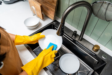 Close up woman hand washing plate. Female housekeeper cleaning some dish plate after dining....