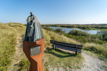 Monument of Victor Westhoff with bench at a lake near the Badweg in Terschelling