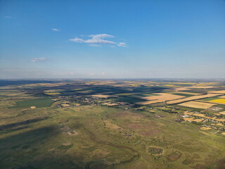 Drone shot showing lush farmland and grassy meadows beneath a cloudy blue sky hinting at upcoming...