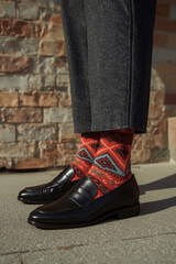 Close up image of patterned socks paired with leather loafers, modern sophisticated street style, men's fashion.