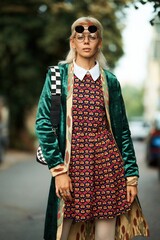 A fashionable woman showcases her unique style with an eye-catching heart-print dress and velvet...
