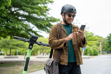 Young Asian man rent the scooter EV scan by smartphone. Sustainable save energy lifestyle. Commute...