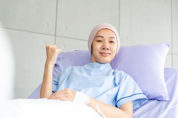 Asian female cancer patient resting in hospital bed with IV line. Undergoing chemo treatment...