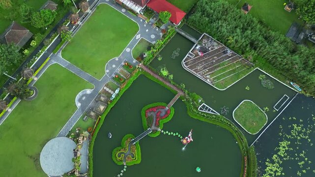Aerial view of the tranquil Danau Beratan temple and gardens, with lush green lawns and intricate water features, Candikuning, Kabupaten Tabanan, Indonesia.