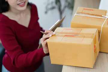 E-commerce. Woman labeling packages and managing inventory at home.