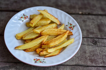   French fries on wooden background. Home made   organic    potatoes
