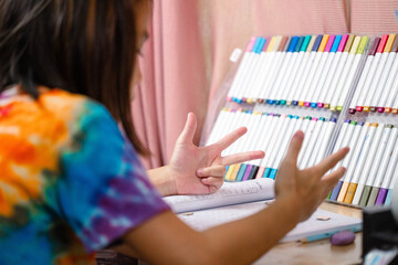 Two elementary school girls are studying at their desks at home. Two cute schoolgirls are diligently doing their homework.