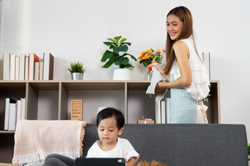 Mother Spraying Cleaner While Child Plays in Living Room