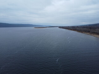 Tranquil Waterscape: A serene body of water under an overcast sky, inviting contemplation. The...