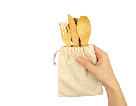 Hand holding bamboo reusable cutlery set in fabric pouch, isolated on a transparent background
