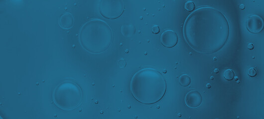 Macro abstract image of dark blue liquid bubbles with smooth transparent textures and soft gradient background.