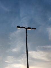 Close up of a street light against a blue sky with some wispy clouds, minimal, vertical shot,4k