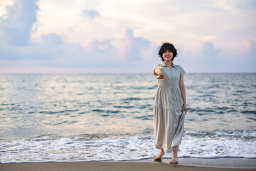 夕暮れの海辺で花火を楽しむ女性モデルの柔らかなボケ感を活かしたポートレート