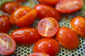 Close-up of fresh juicy cherry tomatoes, sliced in half, being prepared for cooking. Healthy eating and food background concept