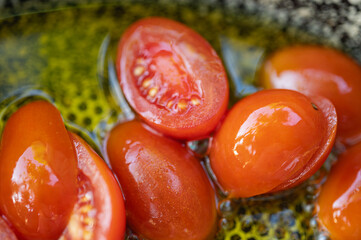 Close-up of fresh juicy cherry tomatoes, sliced in half, being prepared for cooking. Healthy eating and food background concept