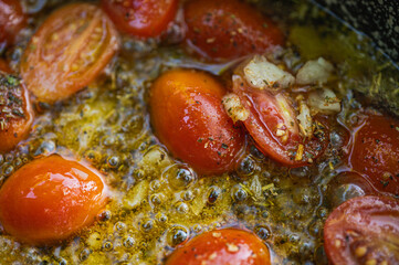 Close-up of fresh juicy cherry tomatoes, sliced in half, being prepared for cooking. Healthy eating and food background concept