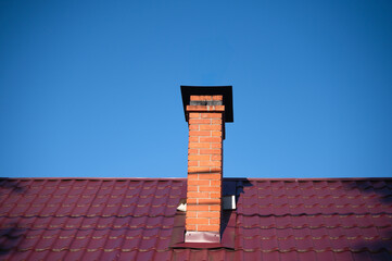 The tall chimney contrasts beautifully with the clear blue sky, showcasing architectural beauty