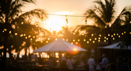 Golden hour gathering under palm trees, blurred figures enjoying a sunset event.