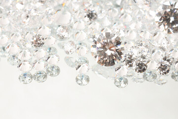 Many shiny diamonds on light background, closeup