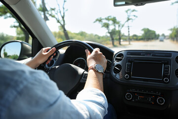 Man driving car with steering wheel, closeup