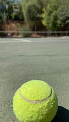 Pelota de tenis en una cancha de pista dura.