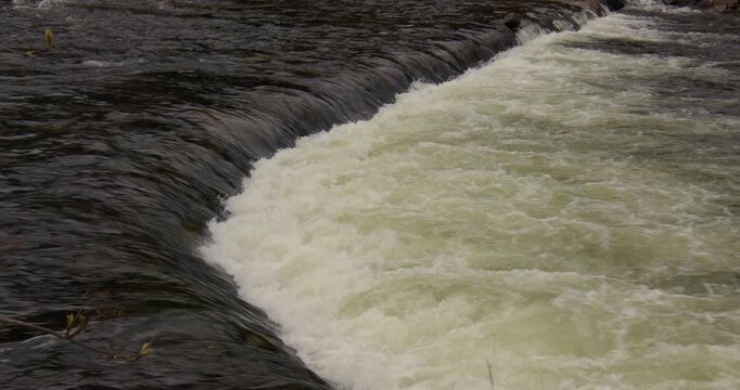 mid shot of river Elo flowing over a small weir, river control at Eldfjord