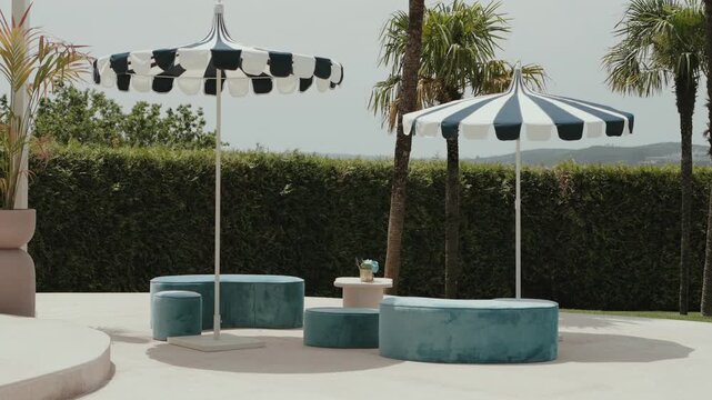 shaded outdoor lounge with round benches and parasols on sunny day