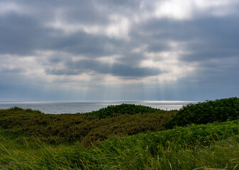 Sonnenstrahlen durchbrechen Wolken an der Nordsee