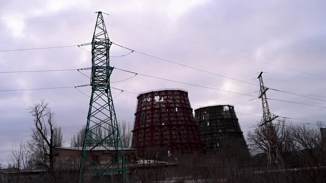 A power plant's cooling towers destroyed by a Russian missile strike in Kramatorsk, Ukraine. Dusk view of war-torn energy infrastructure on the Donbas frontline during the ongoing conflict.
