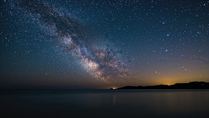 Fototapeta premium Stars sparkle above a peaceful sea and remote coastline at night