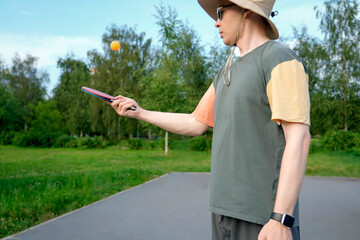 A player stands poised to serve in a vibrant outdoor ping pong match, showcasing skill and focus...