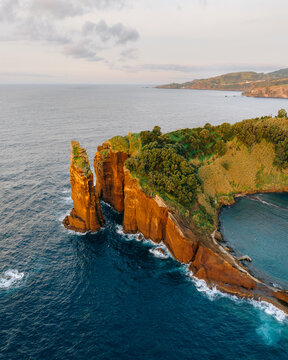Aerial view of the rugged cliffs of Ilh&Atilde;&copy;u de Vila Franca do Campo meet the deep blue sea under a soft sky, Vila Franca do Campo, A&Atilde;&sect;ores, Portugal.