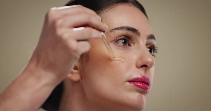 Skincare, face and serum application for beauty, dermatology or glow. Cosmetic product, pipette or model apply hyaluronic acid, vitamin c or collagen treatment with essential oil on studio background