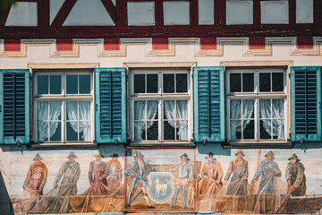 Facade of a traditional building in Ermatingen Switzerland featuring a large painted mural of...