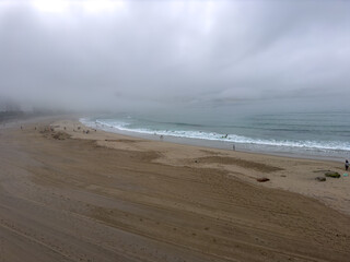 Foggy Beach Scene with Sparse Visitors