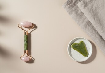 Obraz premium Elegant beauty treatment set featuring rose quartz roller and gua sha stone