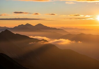 Fototapeta premium A golden sunrise over layered misty mountains