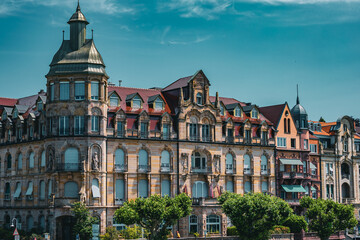 Obraz premium Panoramic view of beautifully preserved Art Nouveau and historic buildings along the Rhine River in Konstanz Germany. The colorful facades and ornate architecture create a charming cityscape on a brig