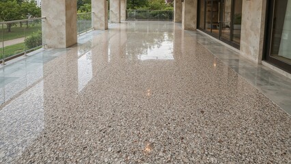 Stone carpet terrace floor made of marble pebbles and epoxy resin, bordered by weathered stone tiles
