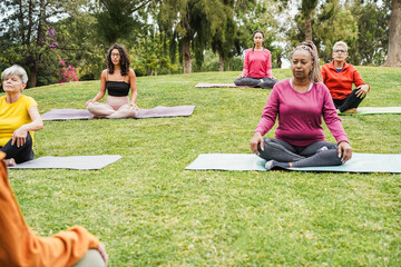 Group of people doing yoga class at city park - Multiracial women doing zen meditation outdoor -...