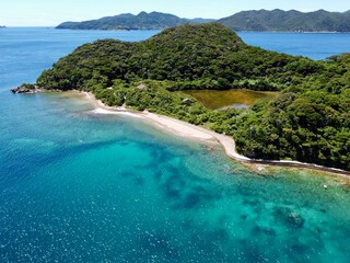 Crystal clear waters and rocky beach at Ikezuka, Naru Island, Goto Islands, Nagasaki, Japan –...