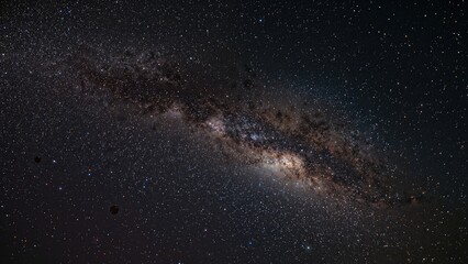 Fototapeta premium Panoramic night sky photo showcasing a spiral galaxy surrounded by countless stars.