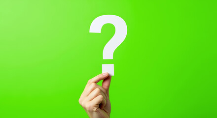 Human hand presenting a white question mark on green background, representing problem-solving, curiosity, FAQ or support topics