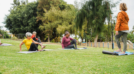 Group of people doing yoga class at city park - Multiracial women doing zen meditation outdoor -...