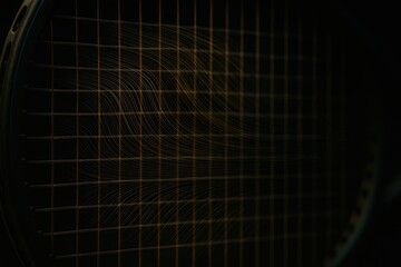 Close-Up of Tennis Racket Strings in Dark Background, Showing Texture and Detail of Strings