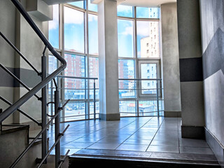 Lighting in a modern building stairway with large windows illuminating the interior space
