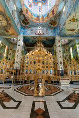 Interior view of an ornate church with vibrant murals and intricate golden details showcasing a...